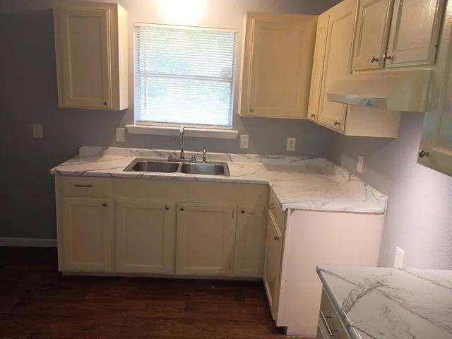 a room with a sink cabinets and utility