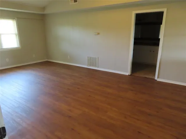 an empty room with wooden floor and closet