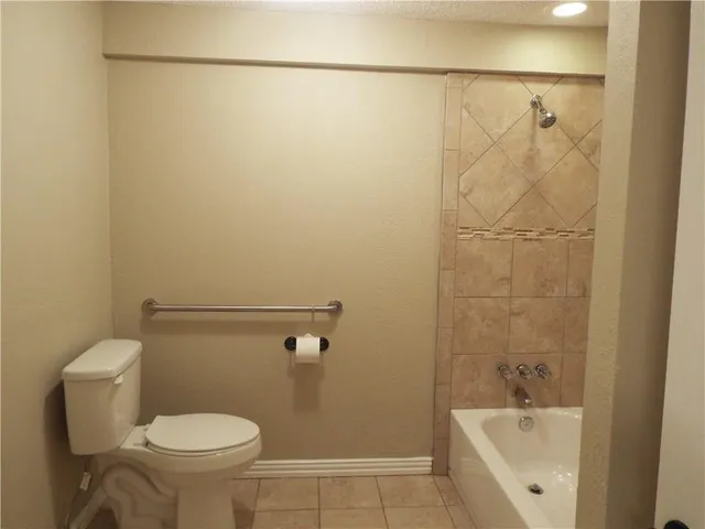 a white toilet sitting next to a bath tub