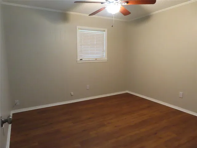 an empty room with a chandelier fan