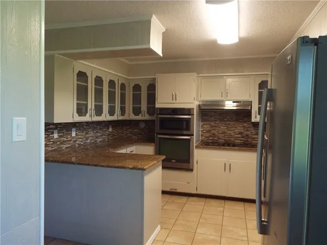 a kitchen with stainless steel appliances granite countertop a refrigerator and a stove