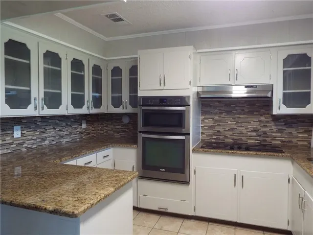 a kitchen with granite countertop a stove and a sink