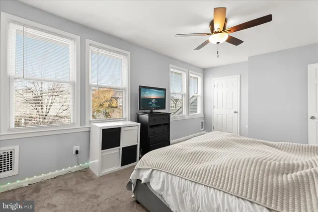 a bedroom with a large bed a chandelier and dresser