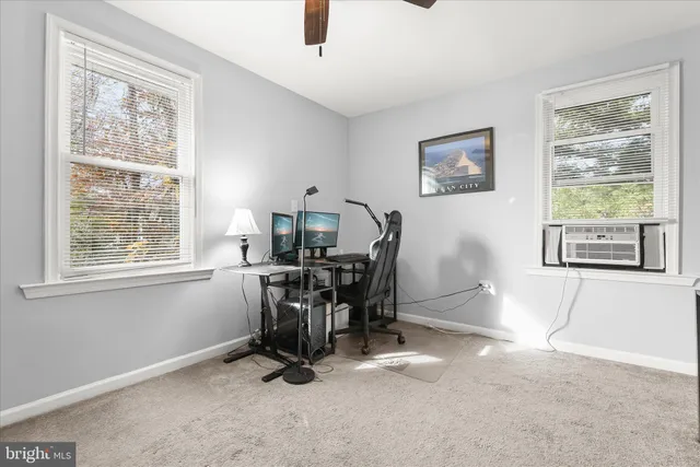 a view of a workspace with furniture and a window