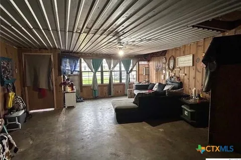 a living room with furniture a flat screen tv and a large window