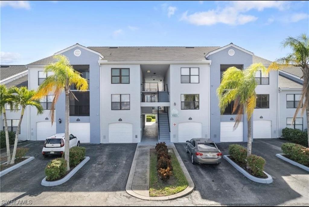 13571 Eagle Ridge Drive, Unit 1325 Fort Myers, FL 33912 - Photo 1 of 17 View of front of house with stucco siding, a balcony, and driveway