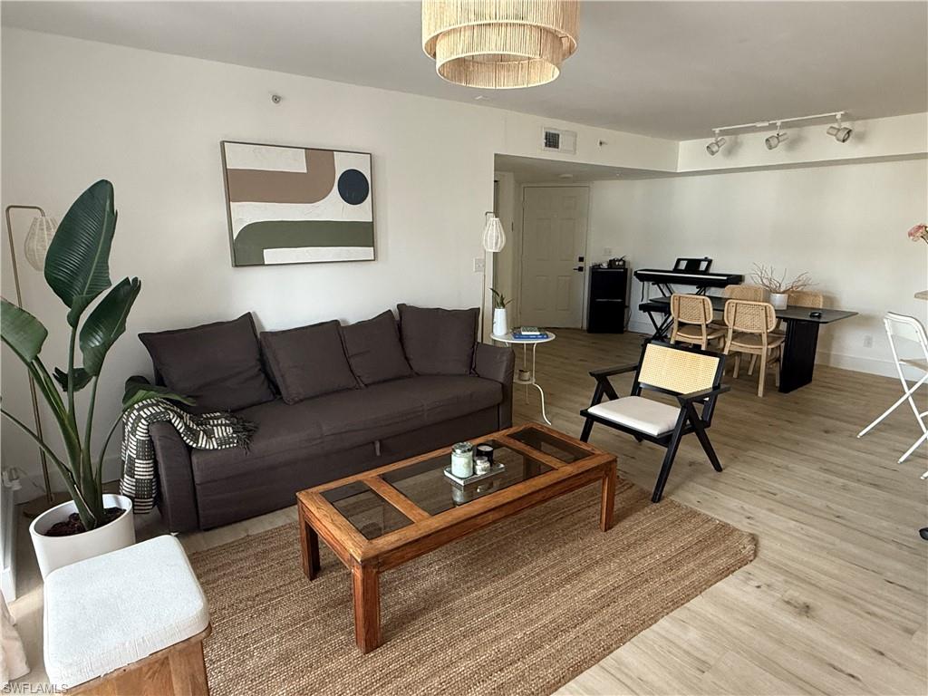 13571 Eagle Ridge Drive, Unit 1325 Fort Myers, FL 33912 - Photo 6 of 17 Living room featuring light wood-type flooring and rail lighting