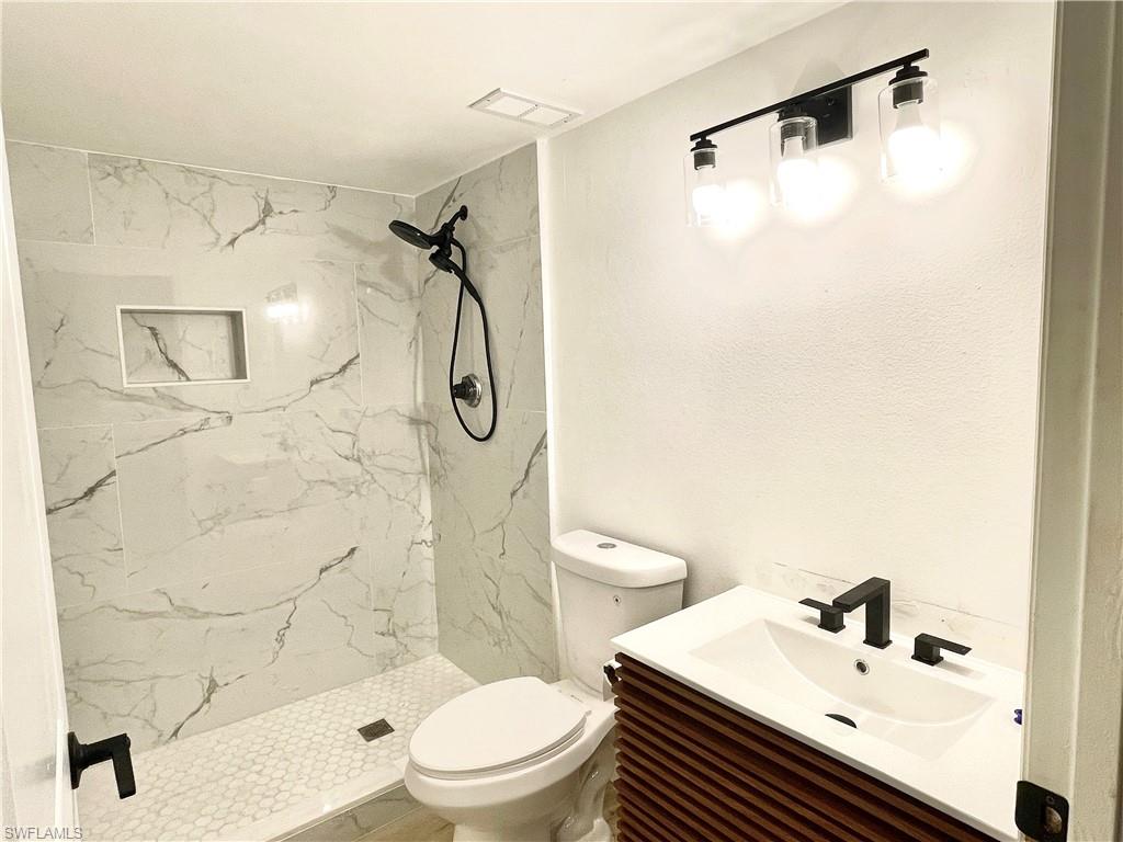 13571 Eagle Ridge Drive, Unit 1325 Fort Myers, FL 33912 - Photo 10 of 17 Bathroom featuring vanity and a marble finish shower