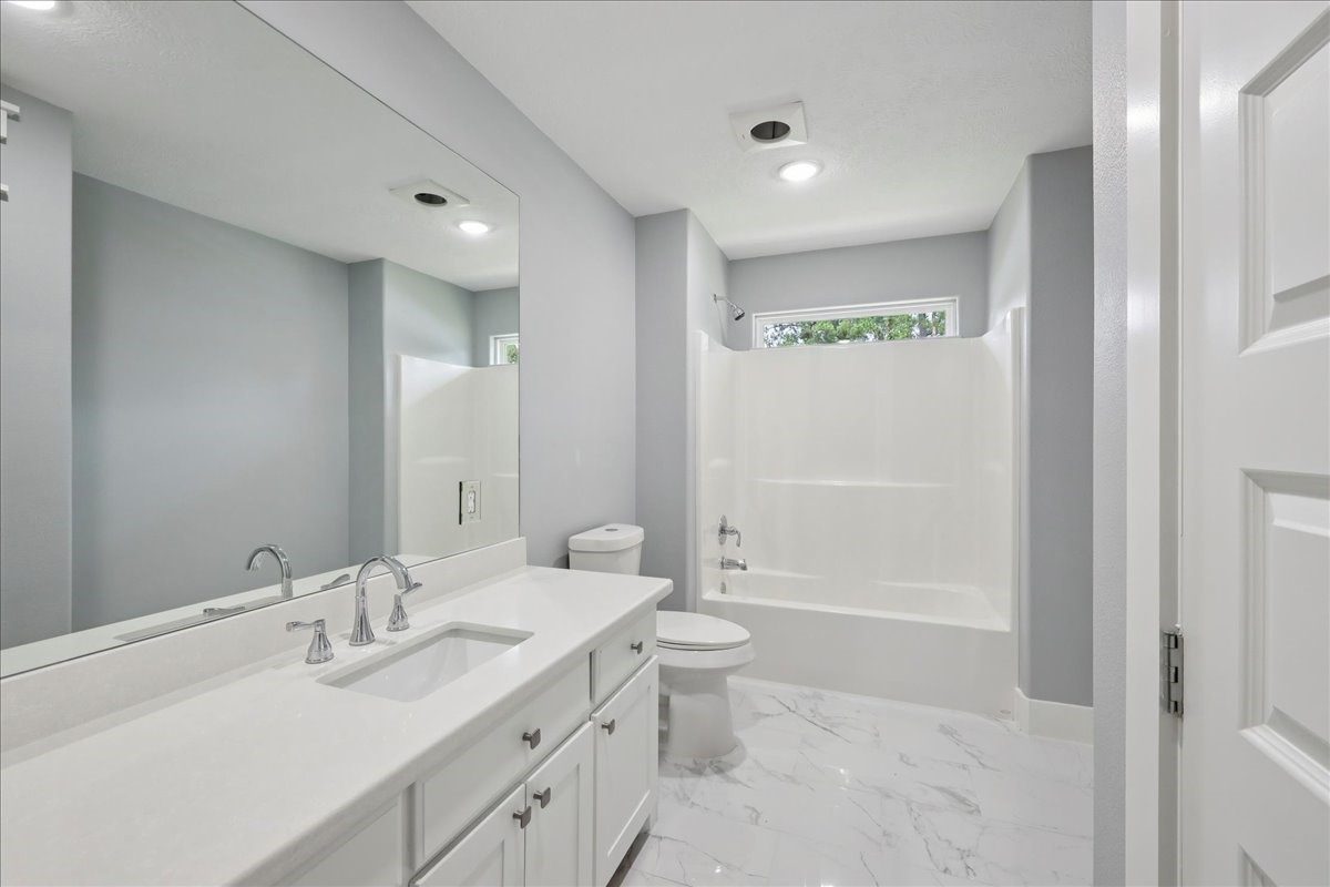 8679 Massey Lake Road Silsbee, TX 77656 - Photo 29 of 37 a bathroom with a double vanity sink toilet and shower