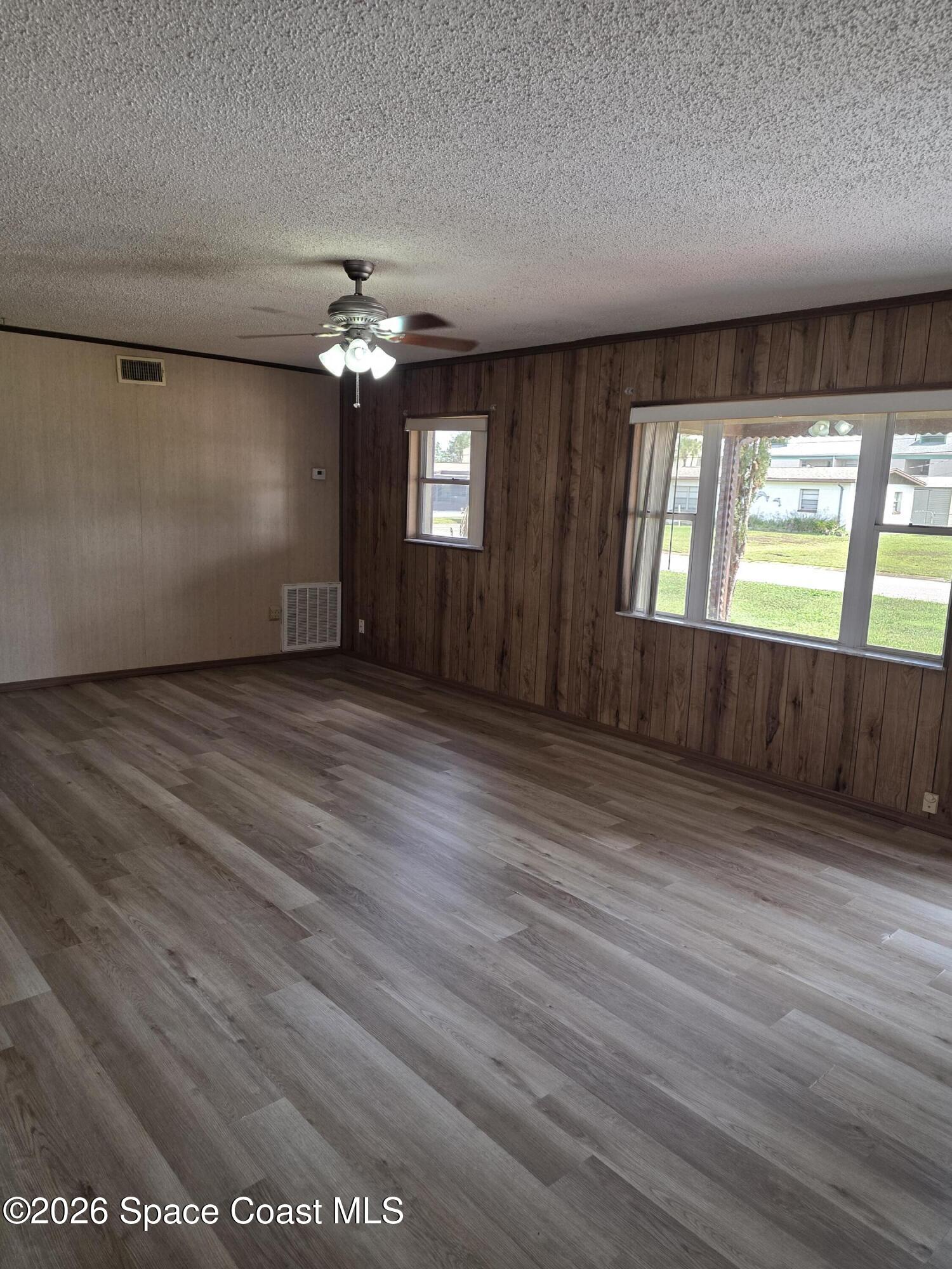 2910 Zephyr Lane Melbourne, FL 32935 - Photo 3 of 16 wooden floor in an empty room with a window