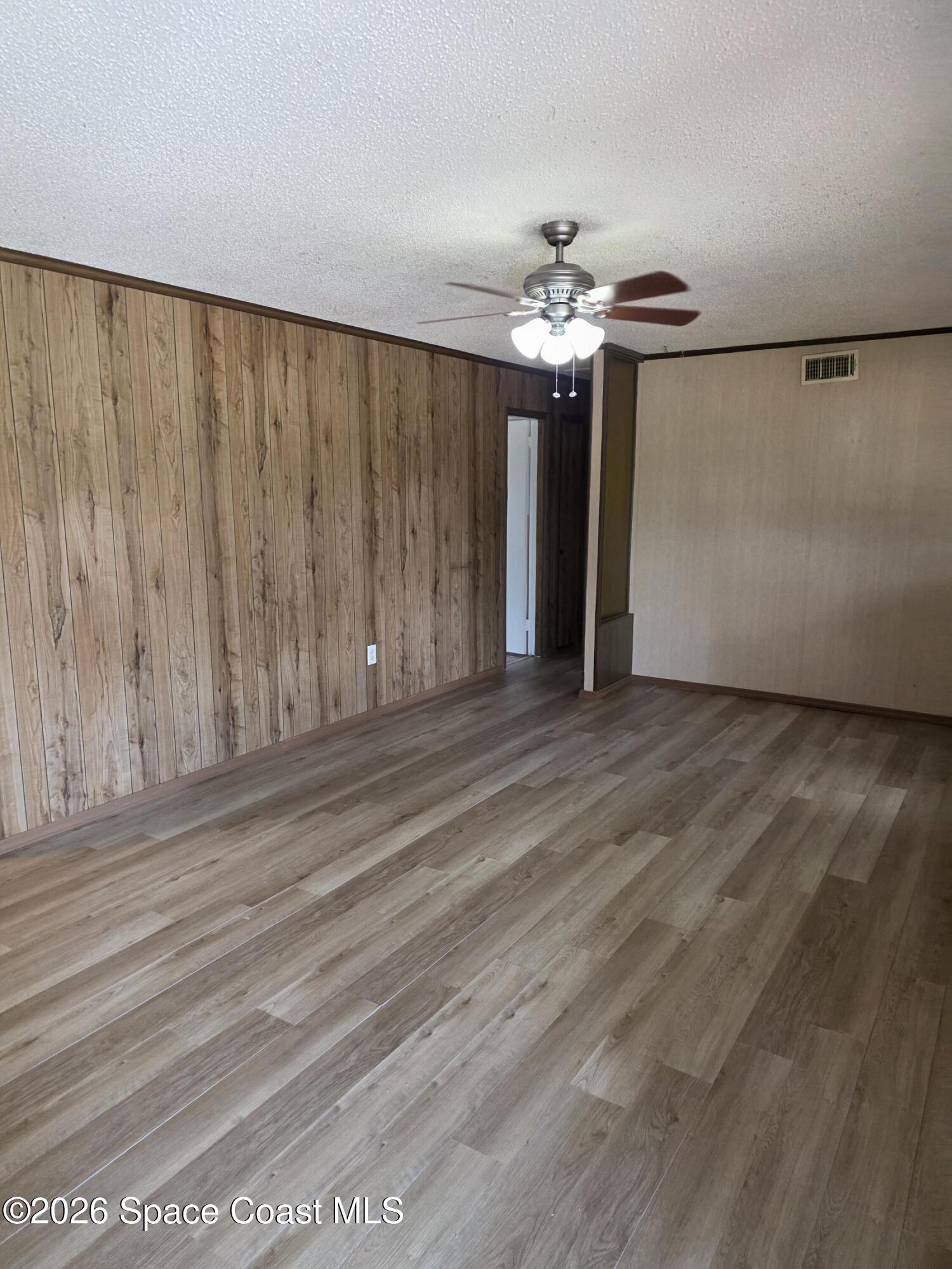 2910 Zephyr Lane Melbourne, FL 32935 - Photo 4 of 16 a view of a livingroom with a chandelier fan and wooden floor