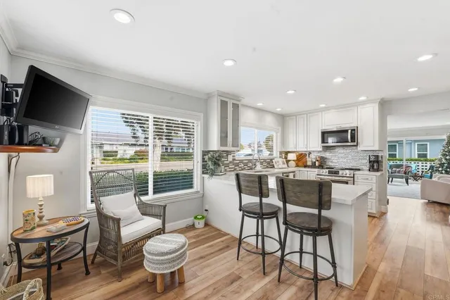 a kitchen with a dining table chairs and flat screen tv