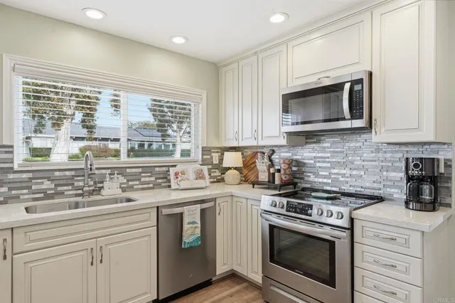 a kitchen with cabinets stainless steel appliances a sink and a stove