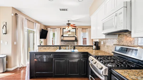 a kitchen with stainless steel appliances granite countertop a stove and a sink