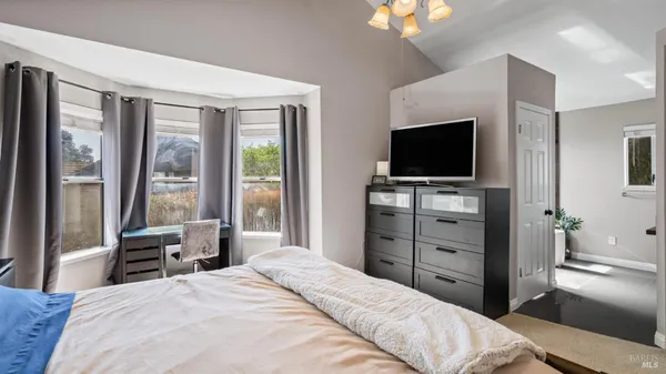 a bedroom with a bed and a flat screen tv