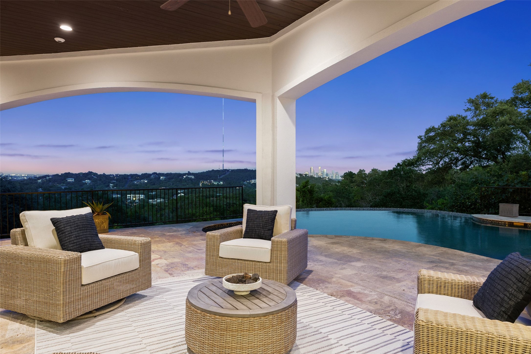 1414 The High Road Austin, TX 78746 - Photo 37 of 40 An inviting outdoor living area features a grand archway and an infinity pool, with a panoramic cityscape view.
