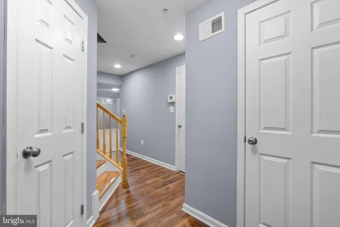 a view of a hallway with a livingroom and a bathroom with sink