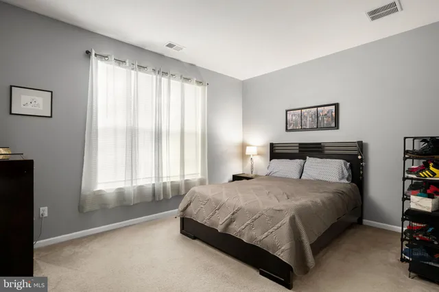 a bedroom with a bed and a large window