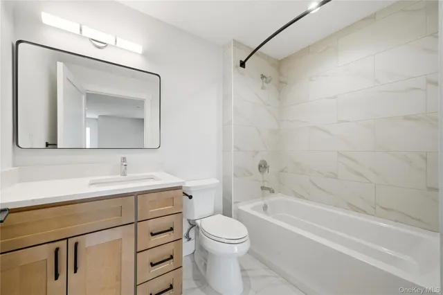 a bathroom with a toilet a sink a vanity and bathtub