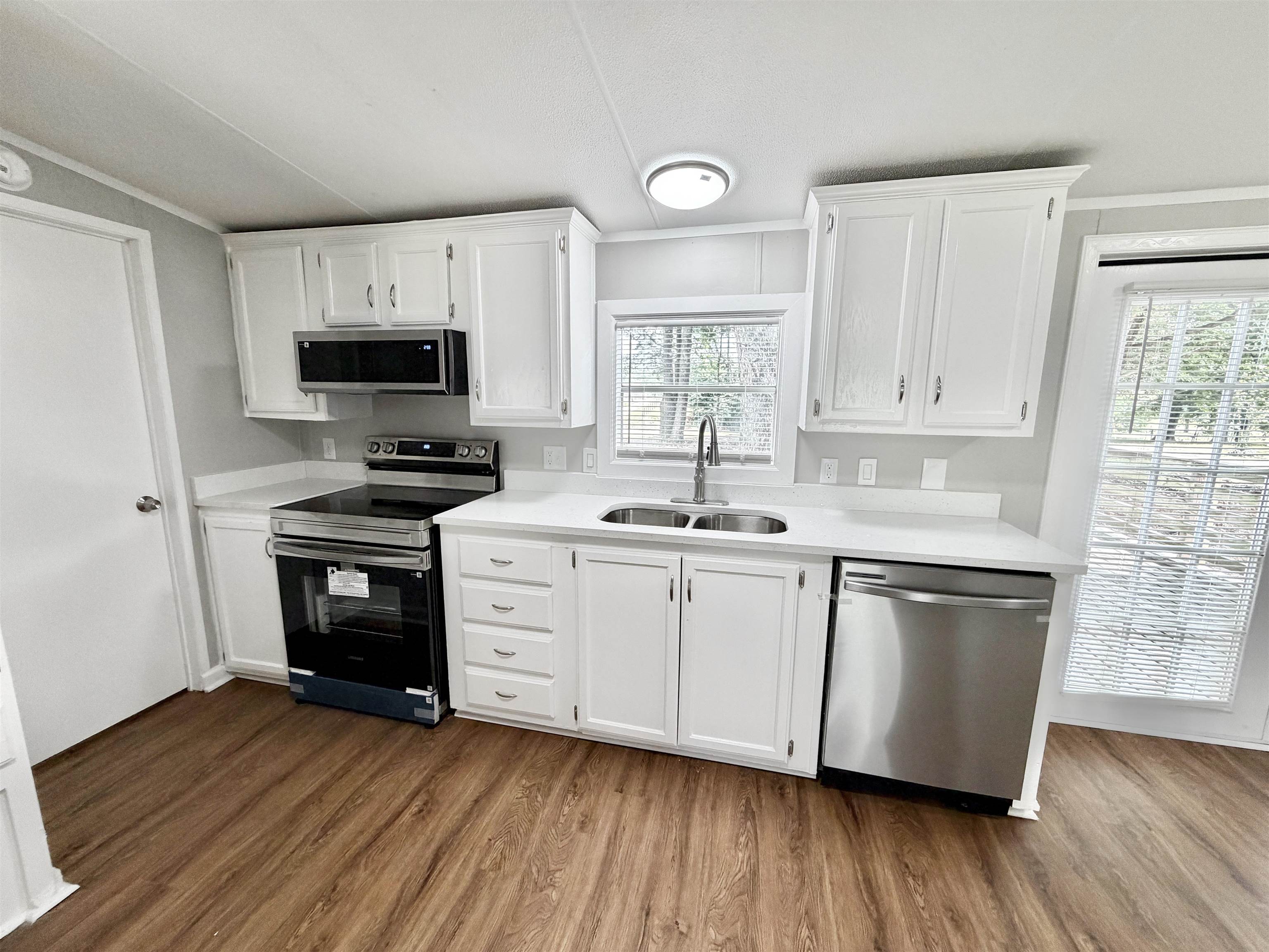 1655 Fayne Road Brighton, TN 38011 - Photo 7 of 28 Modern kitchen featuring wood-finish flooring, white cabinetry, and light-colored countertops