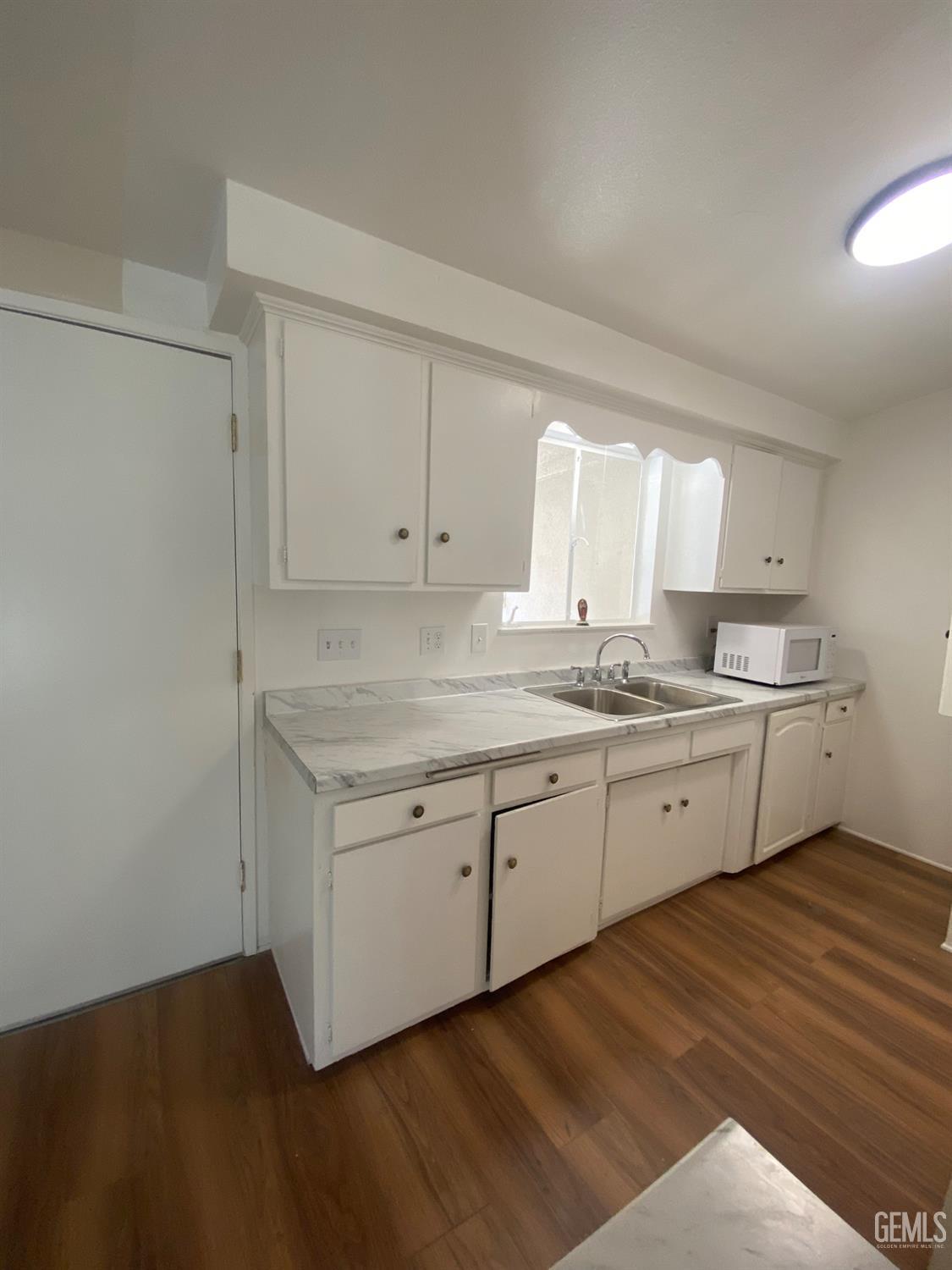 Undisclosed Address Santa Ana, CA 92707 - Photo 10 of 40 a kitchen with granite countertop white cabinets and white appliances