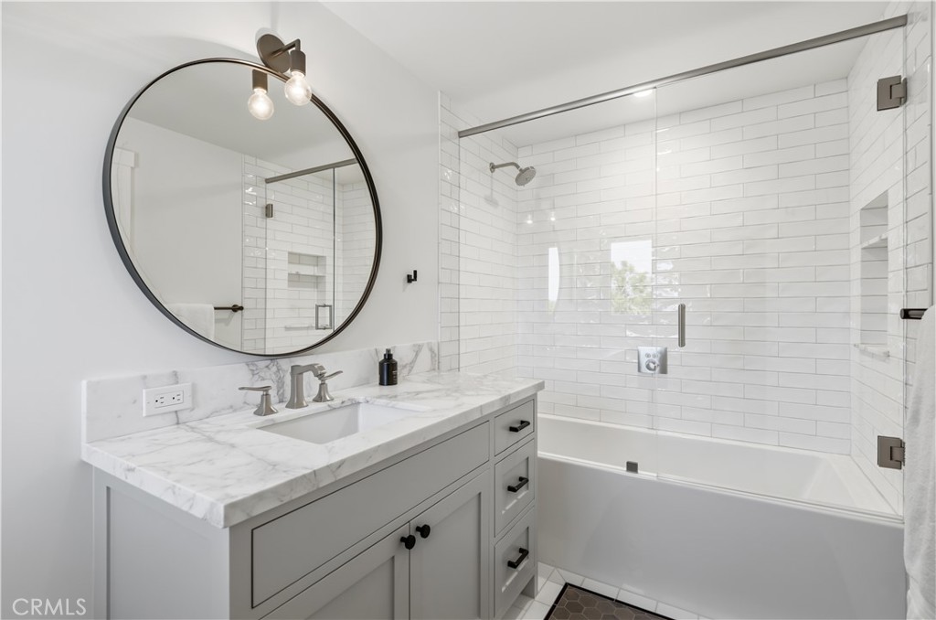 24884 Jim Bridger Road Hidden Hills, CA 91302 - Photo 23 of 31 a bathroom with a granite countertop sink a mirror a shower and a mirror