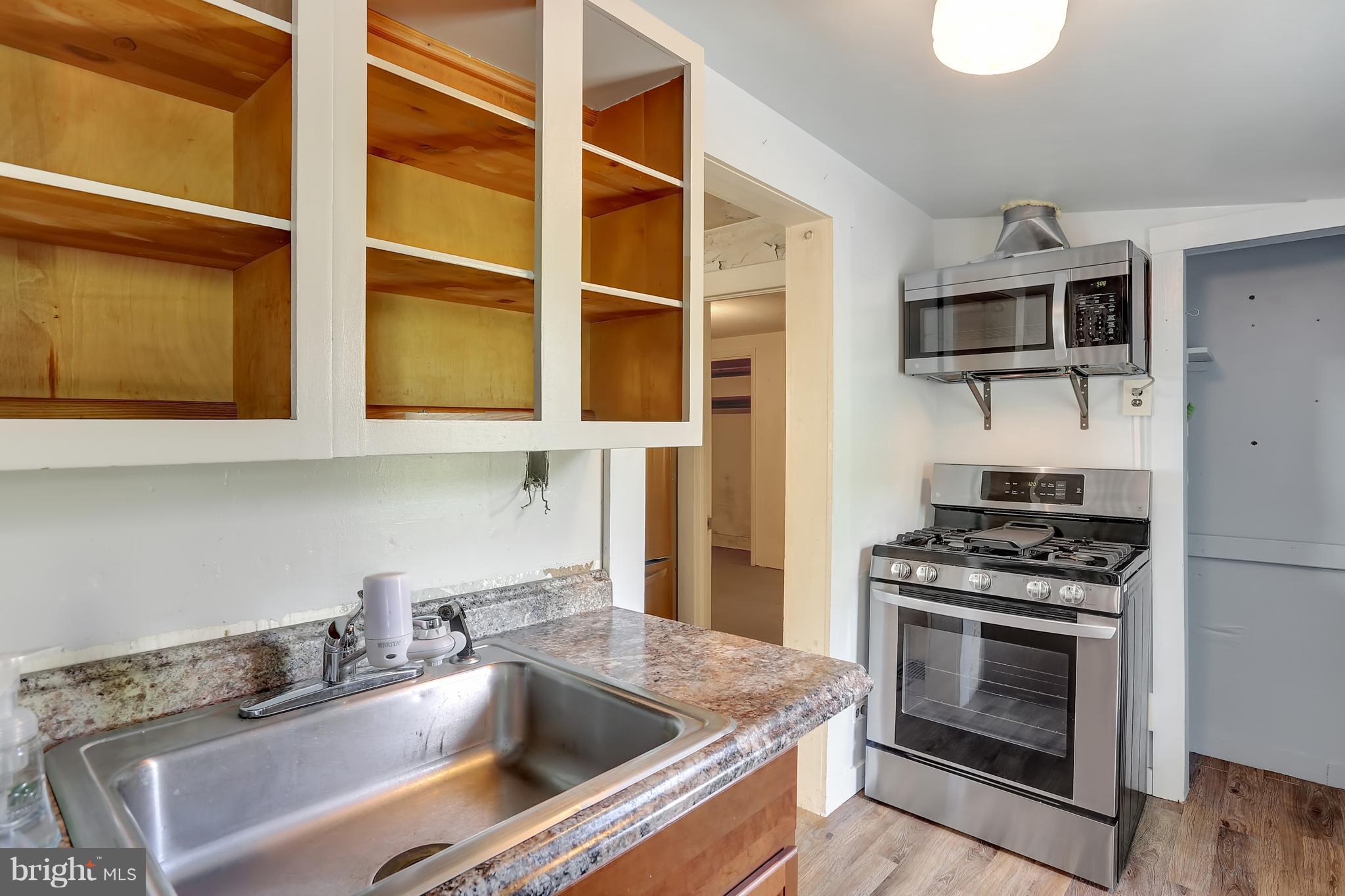 2443 Ridge Road Baltimore, MD 21244 - Photo 8 of 28 a kitchen with stainless steel appliances a stove a sink and a microwave