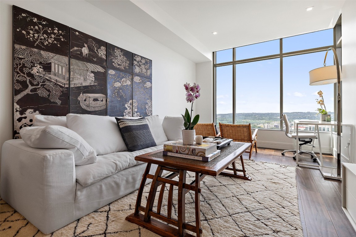 a living room with furniture and floor to ceiling window