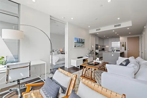 a living room with furniture and a view of kitchen