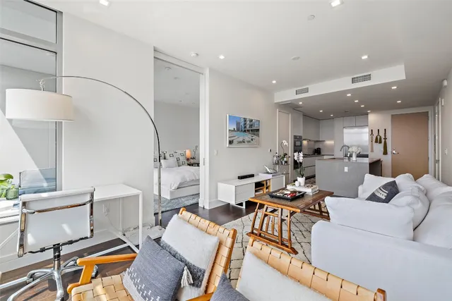 a living room with furniture and a view of kitchen