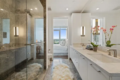 a bathroom with a double vanity sink mirror and shower