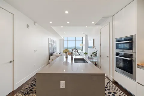 a kitchen with kitchen island a counter top space a sink stainless steel appliances and cabinets