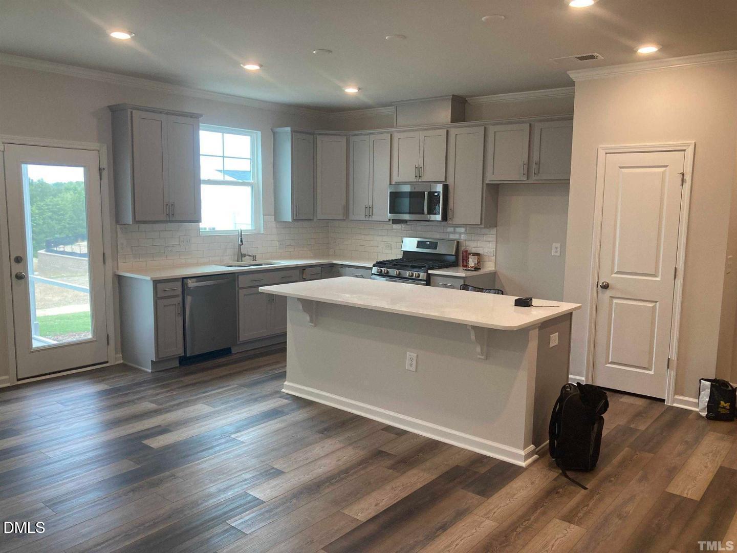 1823 Caen Street Raleigh, NC 27610 - Photo 2 of 13 a kitchen with a sink a stove a refrigerator and cabinets