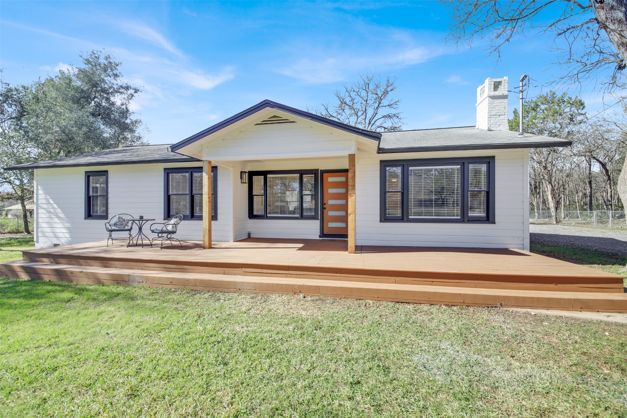 8904 Chisholm Lane Austin, TX 78748 - Photo 14 of 36 Rear view of house with a lawn, a deck, and a chimney