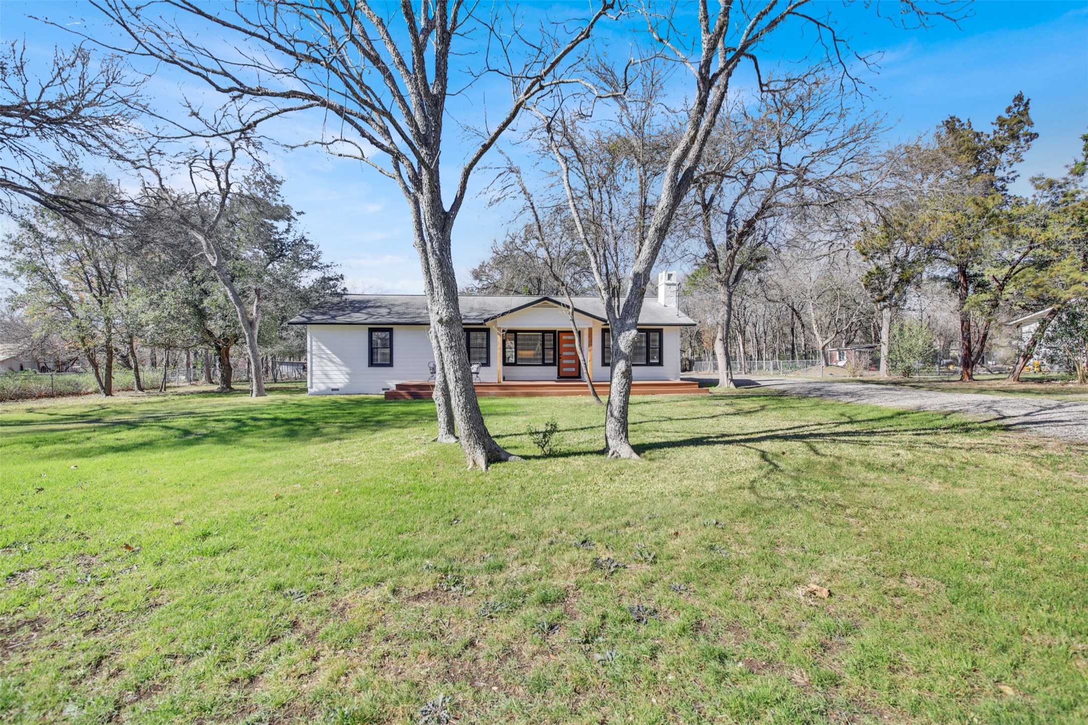 8904 Chisholm Lane Austin, TX 78748 - Photo 27 of 40 Ranch-style home with a front lawn, a chimney, and a wooden deck
