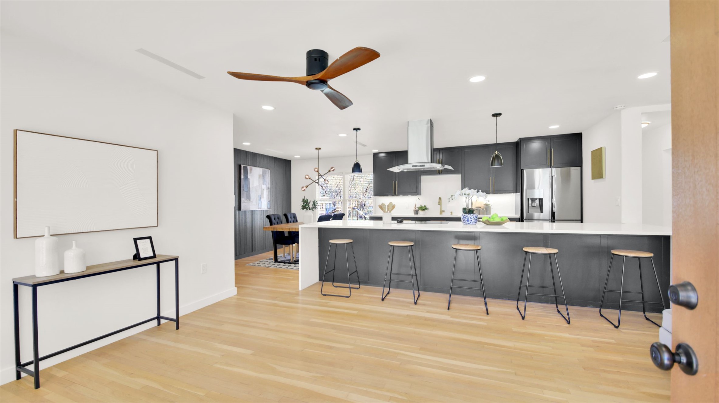 8904 Chisholm Lane Austin, TX 78748 - Photo 6 of 40 Kitchen with a kitchen bar, hanging light fixtures, a peninsula, stainless steel fridge, and island range hood