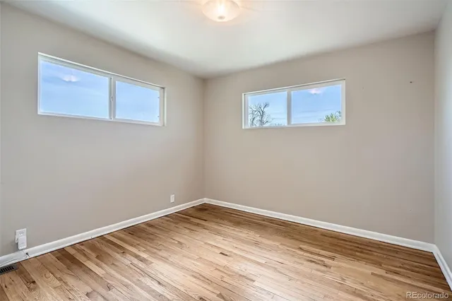 a view of empty room with wooden floor