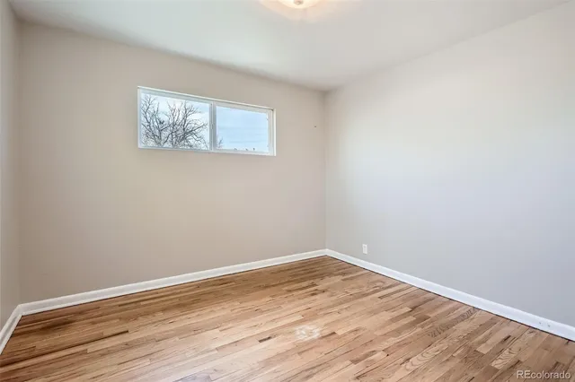 a view of a room with wooden floor and white walls