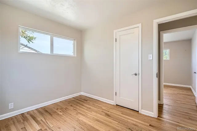 a view of empty room with wooden floor