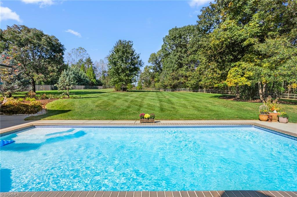 8404 Linville Oaks Drive Oak Ridge, NC 27310 - Photo 3 of 47 Private in-ground, heated pool surrounded by mature trees and landscaping