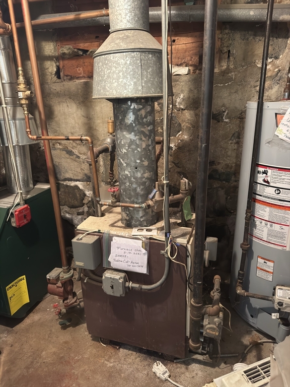 44 Cherry Street, Unit 2 Swampscott, MA 01907 - Photo 36 of 36 a room with water heater and wooden cabinets