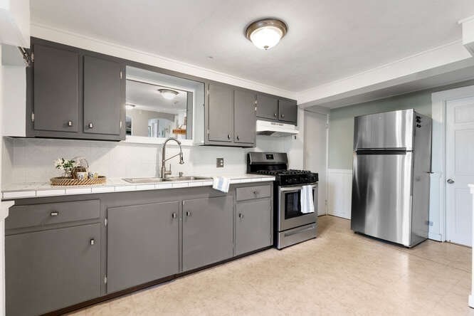 44 Cherry Street, Unit 2 Swampscott, MA 01907 - Photo 8 of 36 a kitchen with white cabinets and stainless steel appliances