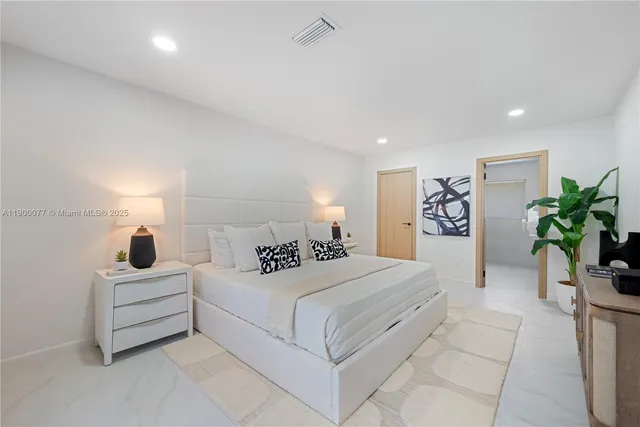 a bedroom with a large bed and a potted plant