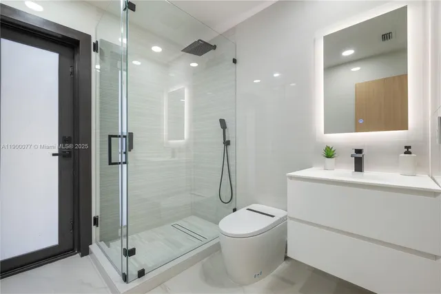 a bathroom with a tub a mirror and a shower