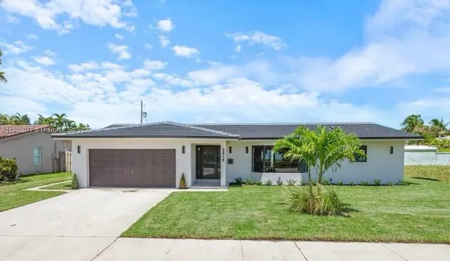 a front view of a house with a garden and yard