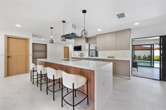 a kitchen with kitchen island granite countertop a table and chairs in it