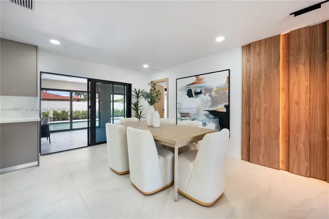 a living room with furniture a large window and glass doors