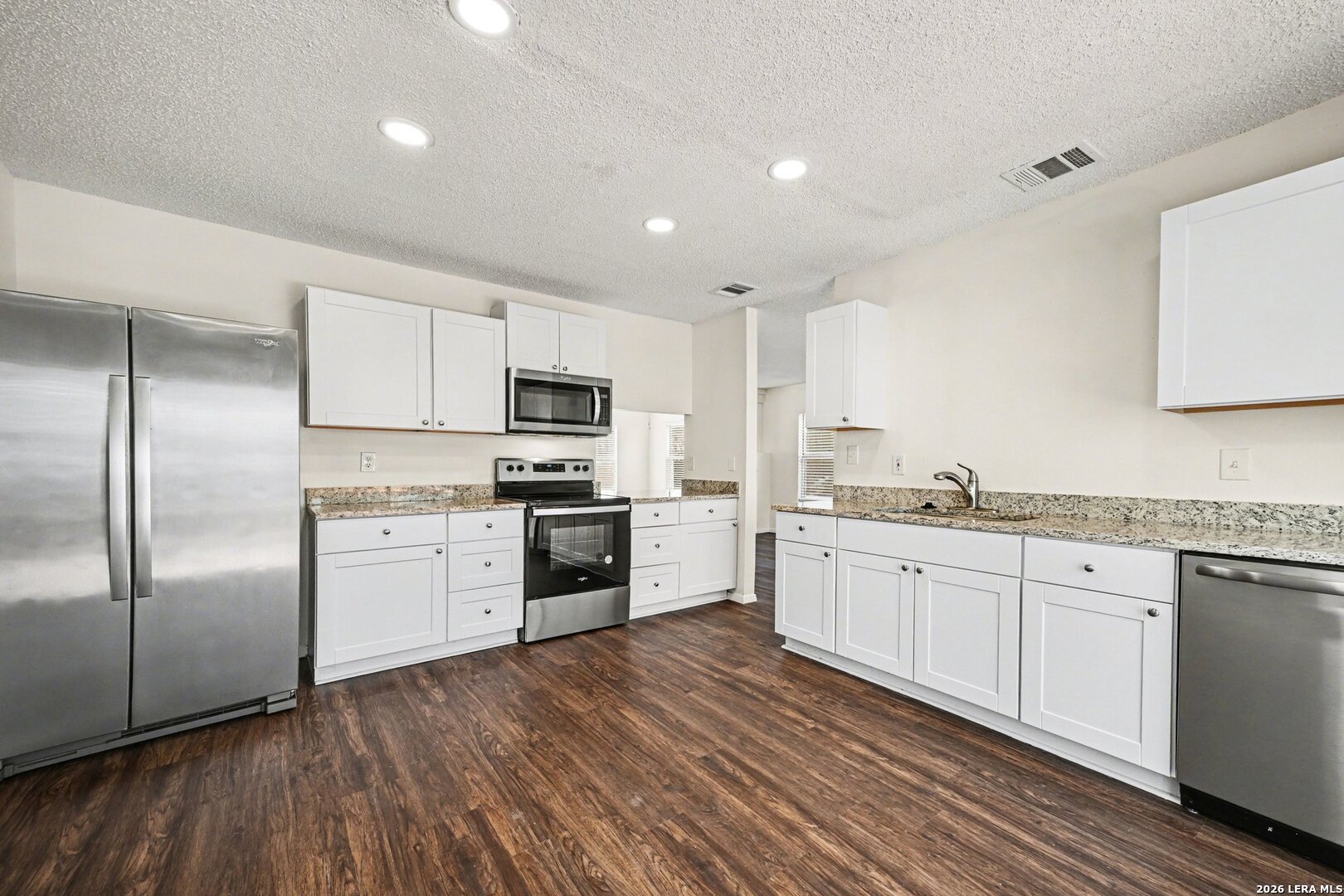 2407 Canyon Rim San Antonio, TX 78232 - Photo 11 of 30 a kitchen with granite countertop white cabinets and stainless steel appliances