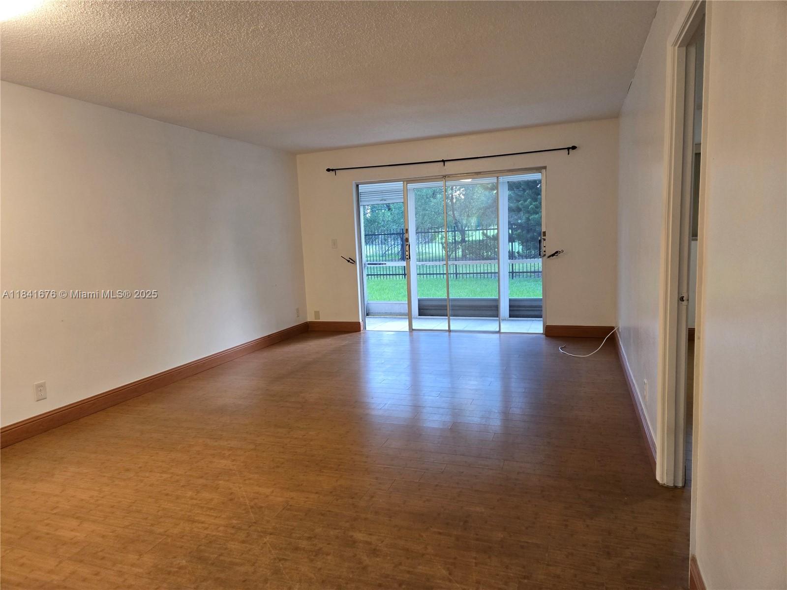 950 Hillcrest Drive, Unit 106 Hollywood, FL 33021 - Photo 8 of 30 an empty room with wooden floor and windows