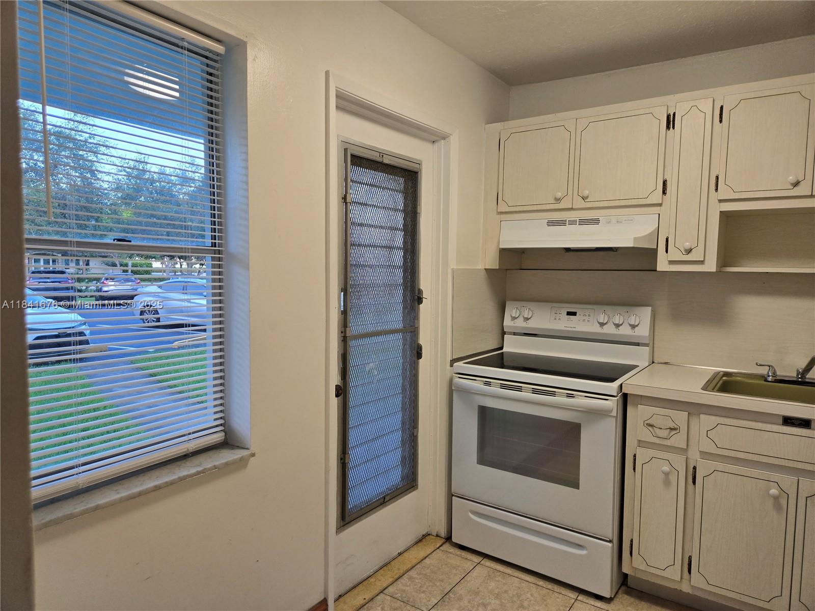 950 Hillcrest Drive, Unit 106 Hollywood, FL 33021 - Photo 9 of 30 a kitchen with white cabinets and white appliances